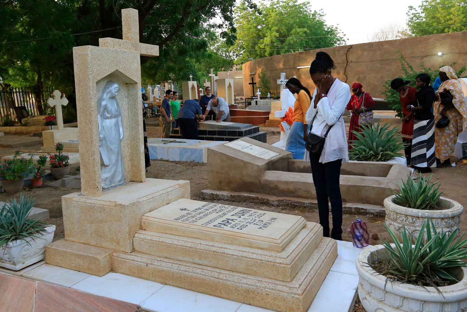 A family prays next to a relative’s grave in a cemetery during All Souls’ Day in Khartoum, Sudan, in this Nov. 11, 2014, file photo. With the continuing pandemic, the Vatican has again extended throughout all of November the opportunity to receive a plenary indulgence for visiting a cemetery to pray for the dead.
